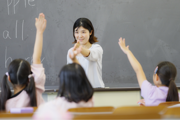 教室で子どもたちが挙手をして授業が進められている様子の写真