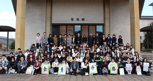 建物の前で大人数が集合して撮影された写真