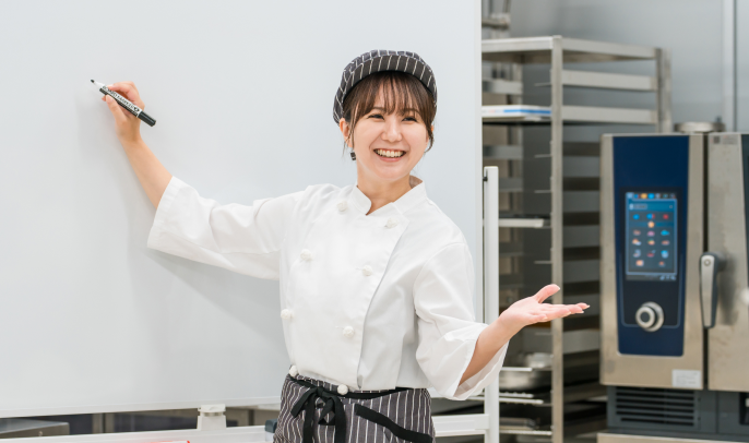 厨房でホワイトボードを使って説明が行われている様子の写真