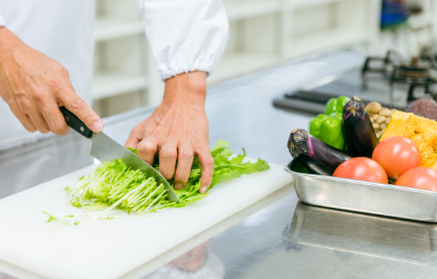 厨房で食材がまな板の上で調理されている様子の写真