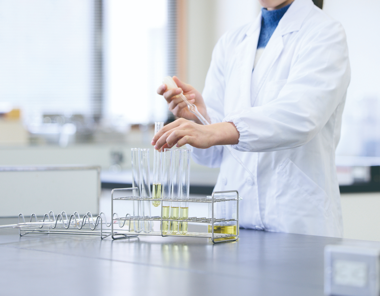 研究室で白衣を着た人の手元の写真