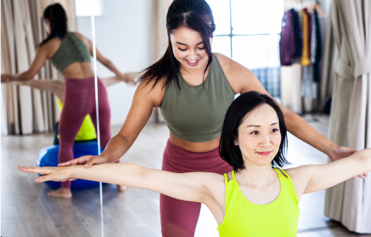 体の動きをサポートしながらエクササイズが行われている様子の写真