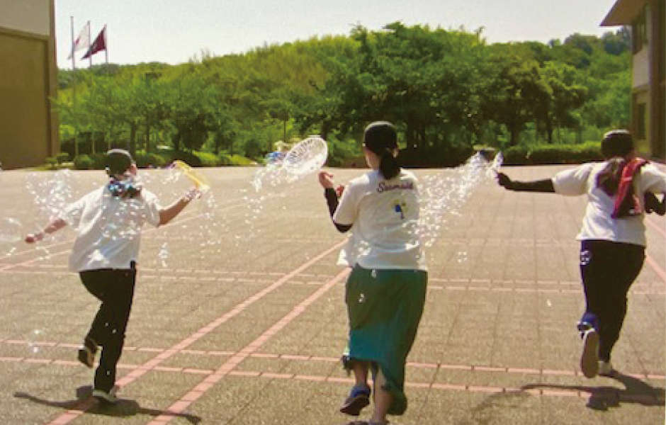 シャボン玉をしながら走っている様子の写真