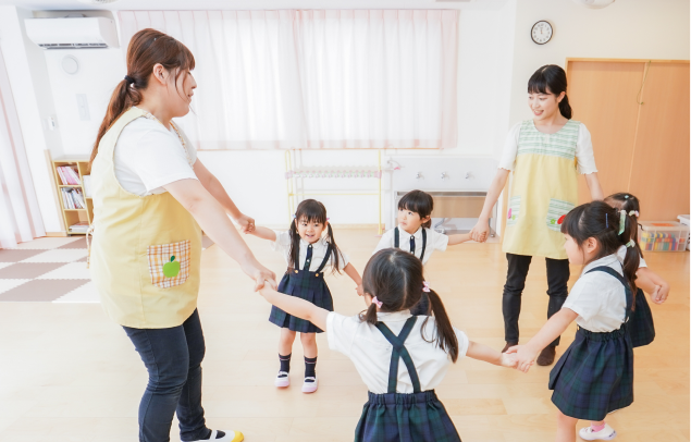 室内で子どもたちが円になって遊んでいる様子の写真