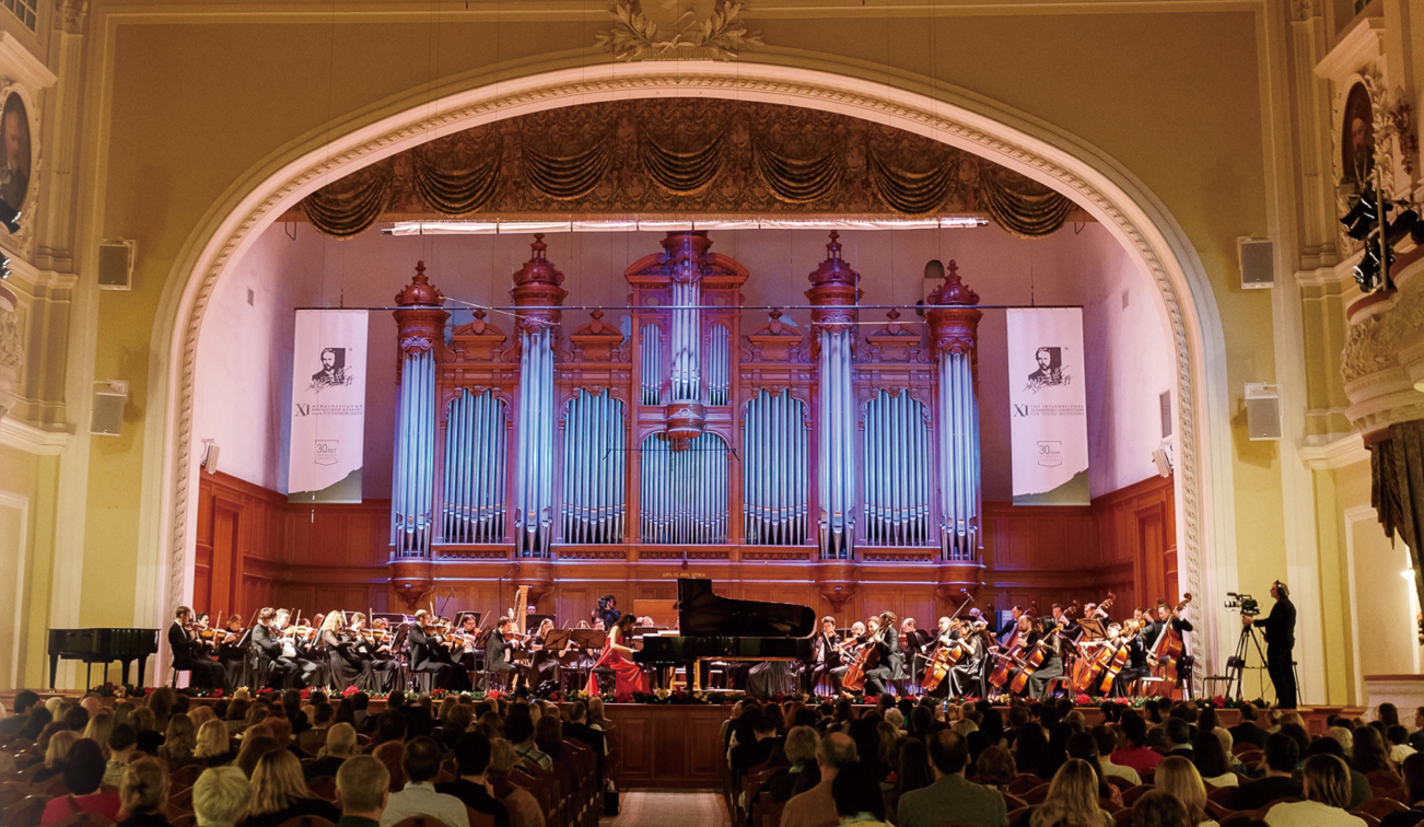 大きなホールで演奏が行われている様子の写真