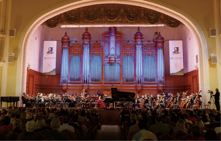大きなホールで演奏が行われている様子の写真